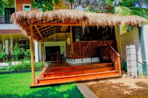 瓦伊卡尔Even Beach Resort的茅草屋顶和庭院楼梯小屋