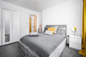 伯明翰BROADWAY SUITE - Newly refurbished stylish apartment with FREE PRIVATE PARKING - Great location的一间卧室配有一张带橙色枕头的大型灰色床。