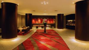 新泻新泻皇冠假日酒店&度假村的大堂设有红色地毯、椅子和桌子