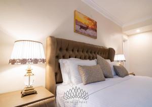 亚的斯亚贝巴The Grand Palace Hotel的一间卧室配有一张床和一张桌子上的台灯