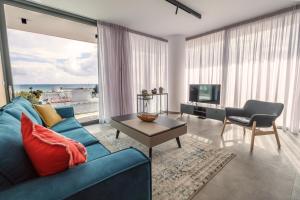 拉纳卡Gaia Seaview Apartment 1的客厅设有蓝色的沙发和大窗户