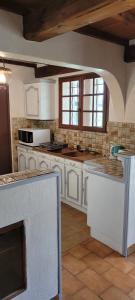 萨雷尔讷Casa Ludese的厨房配有白色橱柜和台面