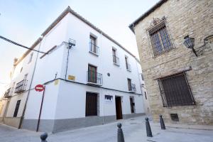 乌贝达Hospedería La casa del Alarife的砖砌建筑旁街道上的白色建筑