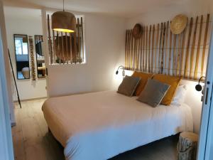 圣马克西姆Casa Louise Suites and Spas privatifs的卧室配有一张带黄色枕头的大型白色床。