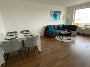 威斯巴登SUITE4ME - Moderne Ferienwohnung I Küche I Balkon I Mainz-Kostheim的客厅配有桌子和沙发