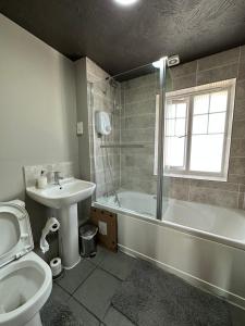 史云顿Orchard House - Great Design, Comfortable furnitures, Free Wifi & Free Parking, Nice tidy Garden的一间带水槽、浴缸和卫生间的浴室