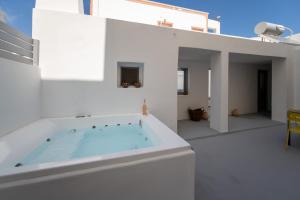 卡马利Villa Tholos & Prive Jacuzzi的浴缸位于白色房子的顶部