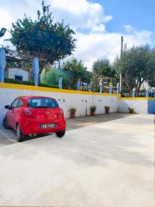 特罗佩阿Le Twins -Bed and Breakfast的停在停车场的红色汽车