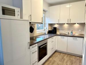 格洛米茨Vogelnest的白色的厨房配有白色橱柜和水槽