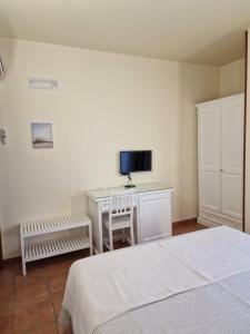 滨海波利尼亚诺卡萨莱棣佛尼斯乡村民宿的一间卧室配有一张床和一张书桌及电视