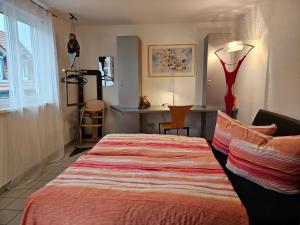 施韦青根Komfortables 3-Zimmer Apartment in Schwetzingen zwischen Mannheim und Heidelberg的一间卧室配有一张床、一张桌子和一个窗户。