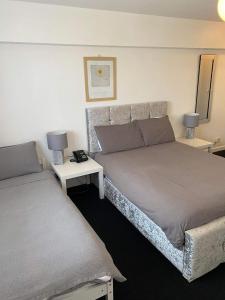 North Cornelly格林阿里克汽车酒店的一间卧室设有两张床和两张带台灯的桌子。