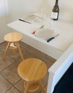 热夫雷尚贝尔坦Gevrey Wine Hôte的一张带两把椅子的白色桌子和一瓶葡萄酒