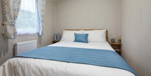 米勒姆Beauview Brand New For 2023 Wi-Fi and Smart TV的卧室配有蓝色和白色的床,设有窗户