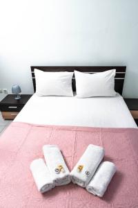 塞萨洛尼基Soleado, Nilie Hospitality MGMT的一间卧室配有一张床,上面有两条毛巾