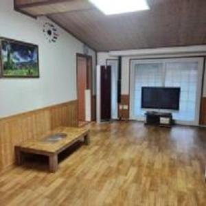 洪川郡Hongcheon fence house的客厅铺有木地板,配有平面电视。