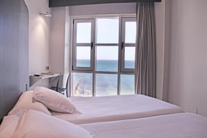桑坦德奇凯酒店的一间卧室设有一张床和一个海景窗户