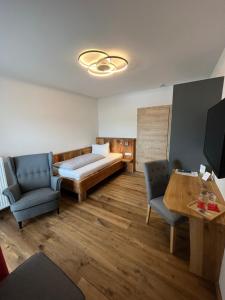 加尔米施-帕滕基兴Hotel garni Alpengruss的一间卧室配有一张床、两把椅子和一张桌子