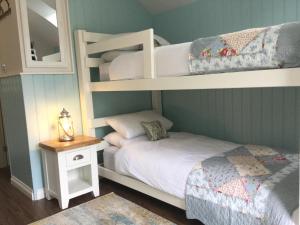 德里门Angel Cottage的一间卧室设有两张双层床和一张带台灯的桌子