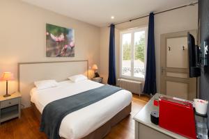 拉尚塞的伊夫乐银杏 -罗伯特艾尔桑高尔夫酒店公园的一间卧室设有一张大床和一个窗户。