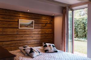 SkulteMiera osta atpūtai Skultē Garāža的一间卧室设有木墙和一张带枕头的床。