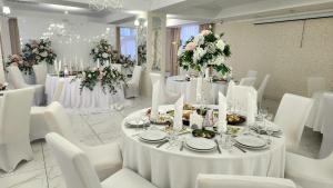 基辅维尔霍维纳酒店的用餐室配有白色的桌子和白色的椅子