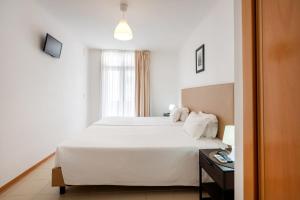 波尔蒂芒罗沙米兰特公寓的卧室配有白色的床和窗户。