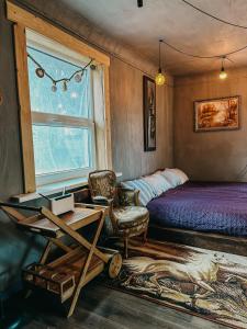 塔尔西Private Farm Jakuzzi Sauna in the forest的一间卧室配有一张床、一张桌子和一把椅子