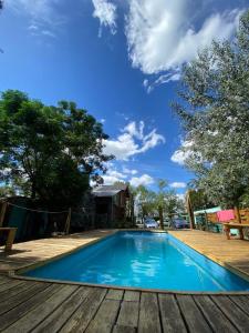 圣米格尔-德尔蒙特Huecubu suites的一个带木制甲板的蓝色游泳池