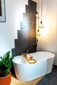 克卢日-纳波卡Thome Ego Flat的植物浴室内的白色浴缸
