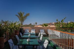 马拉喀什Riad Le Saadien的阳台的天井配有桌椅