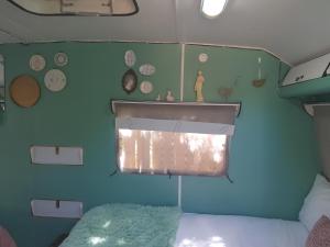 奥茨胡恩绿洲香提背包客旅舍的一间卧室配有一张床,墙上挂着蓝墙,墙上挂着时钟。
