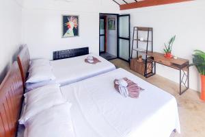 TigbaoSurigao Dream Beach Resort的配有2张床铺、白色床单和桌子的客房