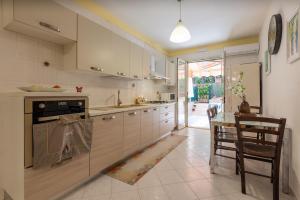 切法卢Paradiso Marino的厨房配有白色橱柜和桌椅