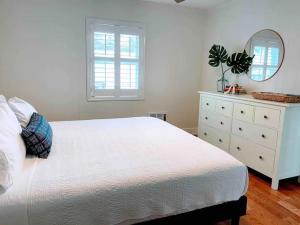 卡罗来纳比奇Vitamin Sea的一间卧室配有一张白色床、梳妆台和镜子