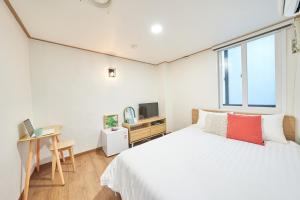 首尔K'STAY Sinchon的一间卧室配有一张床、一张书桌和一台电视。