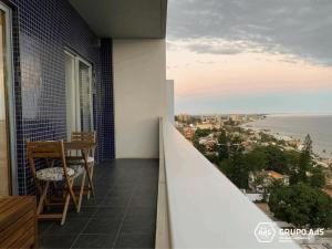 马普托XENON PRIME Urban Apartments的阳台配有桌椅,享有海景。