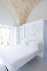 马泰拉Vittorio Veneto Matera Luxury Rooms的白色卧室设有一张大床和大窗户