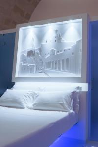 马泰拉Vittorio Veneto Matera Luxury Rooms的一张白色的床,上面有建筑物的照片