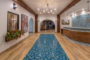 威利斯顿大威利斯顿酒店和会议中心的大堂设有蓝色瓷砖地板和酒吧
