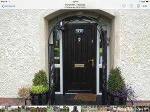 CorrannyFermanagh lakeside Self Catering的两棵植物的房子的黑色前门