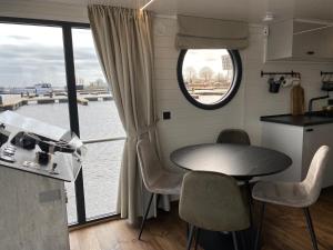OffingawierSeaYou House boat的厨房配有桌椅和窗户。