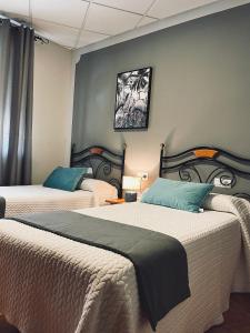 特鲁希略保利诺旅馆的一间卧室设有两张床和一堵墙