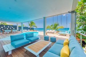 马霍礁Surfsong Villa- Luxury Water Front Villa for 12的客厅配有蓝色的家具,享有海景。