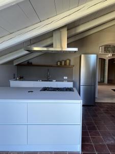 拉莫拉Luxury Langhe Loft的厨房配有白色的柜台和冰箱。