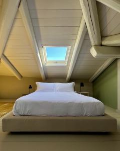 拉莫拉Luxury Langhe Loft的阁楼上的一张带天窗的床铺