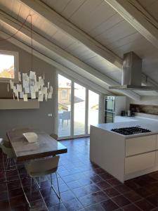 拉莫拉Luxury Langhe Loft的厨房配有桌子和炉灶。 顶部烤箱