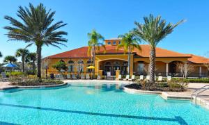 达文波特WATERSONG RESORT Pool & Spa GAMES ROOM 338 by Orlando Holiday Rental Homes的棕榈树建筑前的游泳池