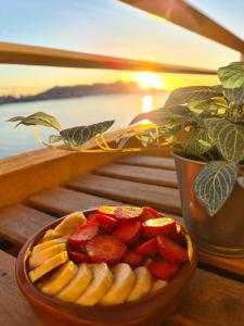 贝尼多姆Bonito triplex con increíbles vistas的放一碗香蕉和草莓在桌子上,伴随着日落