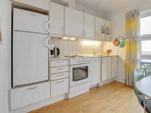 霍耶Apartment Arngerus in Western Jutland by Interhome的白色的厨房配有白色家电和桌子